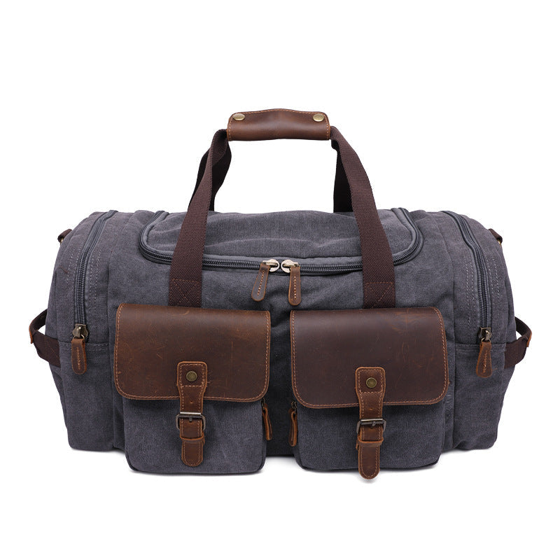Charcoal canvas duffel bag with brown leather pockets and handles