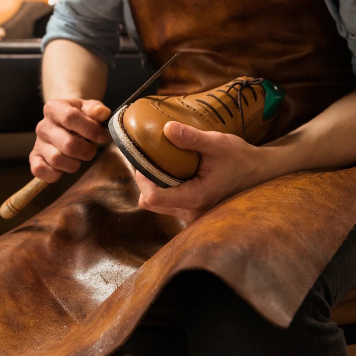 Shoemaker finishing the sole edge of a leather brogue